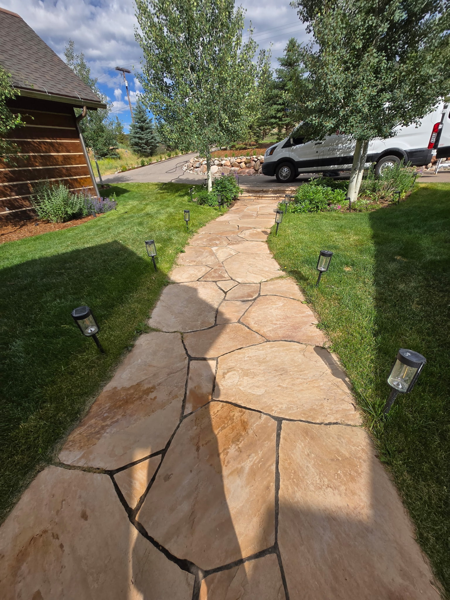 Freshly sealed flagstone walkway lined with garden lights at a Colorado home
