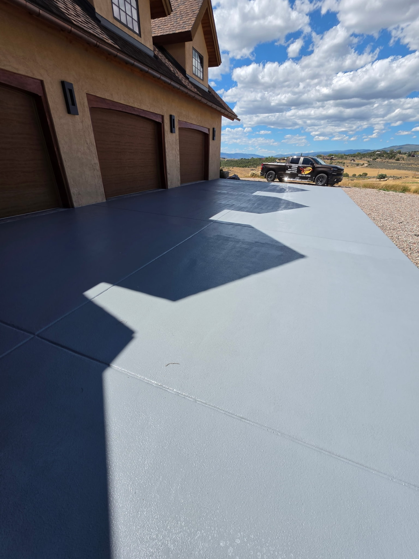 Freshly coated concrete driveway with Adrian's Sealants truck