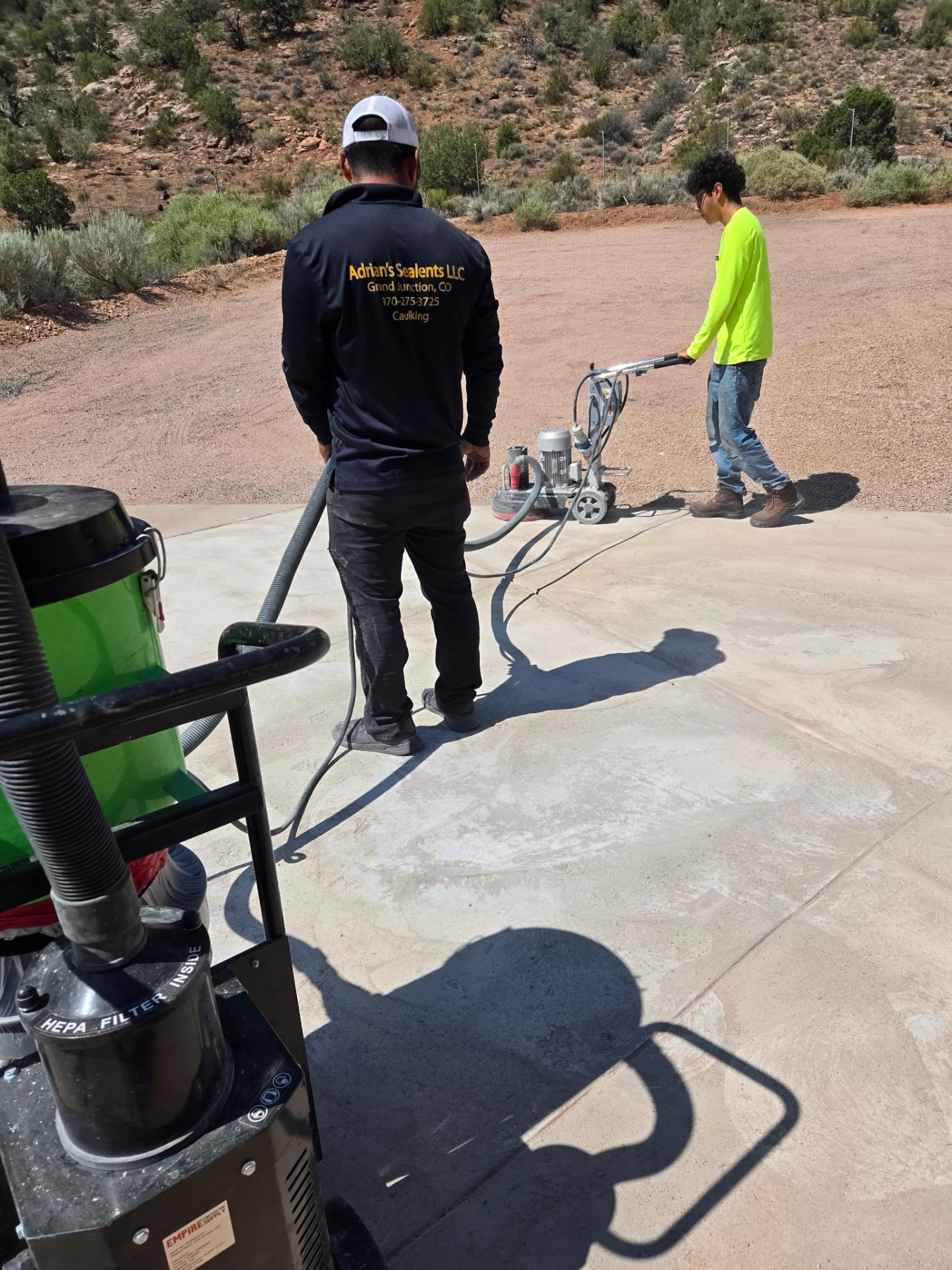 Adrian's Sealants crew grinding and prepping a concrete surface for sealing